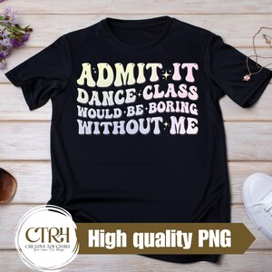 Può includere: T-shirt nero con la scritta "ADMIT IT DANCE CLASS WOULD BE BORING WITHOUT ME" in un font retrò. La maglietta è esposta su una superficie di legno con accessori come occhiali da sole e scarpe.
