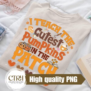 May include: Beige long-sleeve shirt with the text "I Teach The Cutest Pumpkins In The Patch" in orange and brown. The shirt features pumpkin and fall-themed graphics. The words "High quality PNG" are also visible.