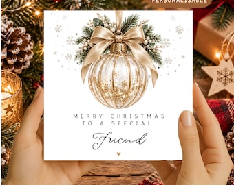 May include: A square greeting card featuring a clear, ribbed Christmas ornament with gold glitter, topped with a gold ribbon and pine sprigs. The text reads: MERRY CHRISTMAS TO A SPECIAL Friend, with a small heart icon below the word Friend.