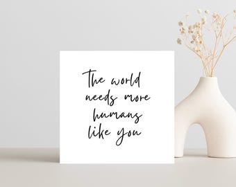 May include: A white card with black calligraphy that reads "The world needs more humans like you."