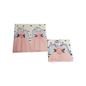 May include: Two ceramic tile coasters with a white background and green polka dots. Each coaster features a hand-painted angel with blue wings, a pink dress, and a green rose.
