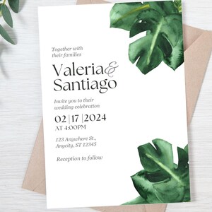 May include: Wedding invitation with a white background and green tropical leaves. The invitation reads "Together with their families Valeria & Santiago Invite you to their wedding celebration 02|17|2024 AT 4:00PM 123 Anywhere St., Anycity, ST 12345 Reception to follow"