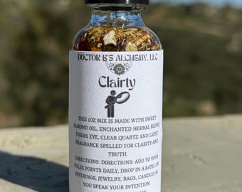 Puede incluir: Una pequeña botella de vidrio con un gotero llena de un líquido transparente y hierbas. La etiqueta dice "Doctor B's Alchemy, LLC" y "Clairty". El texto de la etiqueta describe los ingredientes y las instrucciones de uso. Esta mezcla de 30 ml está hecha con aceite de almendras dulces, mezcla de hierbas encantadas, ojo de tigre, cuarzo claro y fragancia ligera para la claridad y la verdad. Instrucciones: Agregue a sus puntos de pulso diariamente, deje caer en un baño u ofrendas, joyas, bolsas, velas mientras habla su intención.