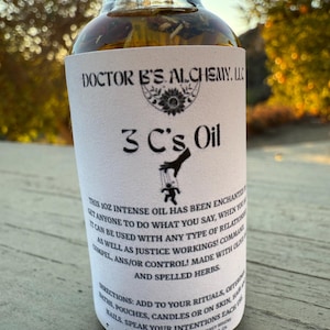 Può includere: Una bottiglia da 30 ml di olio 3 C's Oil, una miscela di erbe e oli, con un'etichetta bianca che recita "DOCTOR B'S ALCHEMY. LLC" e "3 C's Oil". L'etichetta include anche istruzioni per l'uso, indicando che l'olio può essere utilizzato per rituali, bagni, sacchetti, candele o su pelle, capelli e unghie. L'etichetta indica anche che l'olio è incantato per far fare a chiunque ciò che dici.
