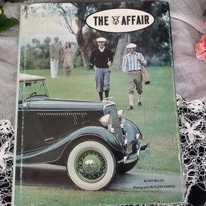 May include: A vintage book cover titled "The Affair" featuring a black convertible car with white-walled tires. The cover includes images of people in golf attire on a green field. The book is by Ray Miller, with photographs by Glenn Embree.