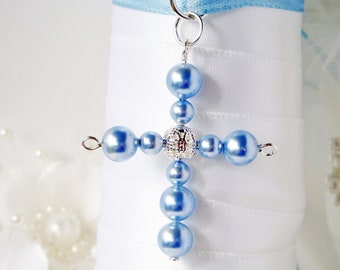 May include: A light blue beaded cross charm with a silver center piece. The cross is hanging from a silver loop.