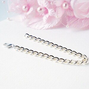Puede incluir: Un brazalete de cadena de plata con cierre de langosta.