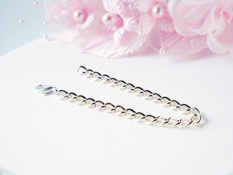 Puede incluir: Un brazalete de cadena de plata con cierre de langosta.