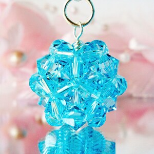May include: A silver pendant with a cluster of light blue crystal beads in a geometric shape.
