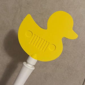 Peut inclure: Un grattoir de fenêtre de voiture en forme de canard jaune avec un manche blanc. Le canard porte un logo Jeep sur son corps. Le grattoir est en plastique et est conçu pour une utilisation automobile.