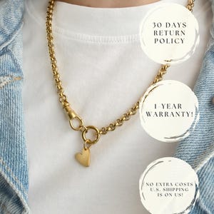 May include: A gold-toned chain necklace featuring a circular link clasp and a small, smooth heart-shaped pendant. The necklace is displayed over a white t-shirt and a light blue denim jacket. Text overlays include 30 DAYS RETURN POLICY, 1-YEAR WARRANTY!, and NO EXTRA COSTS U.S. SHIPPING IS ON US!