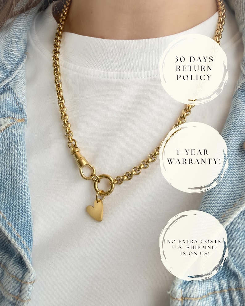 May include: A gold-toned chain necklace featuring a circular link clasp and a small, smooth heart-shaped pendant. The necklace is displayed over a white t-shirt and a light blue denim jacket. Text overlays include 30 DAYS RETURN POLICY, 1-YEAR WARRANTY!, and NO EXTRA COSTS U.S. SHIPPING IS ON US!