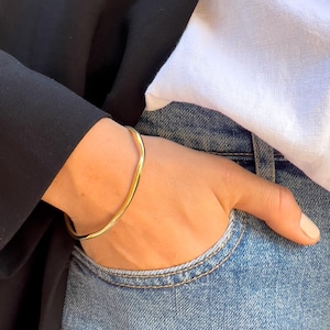 Puede incluir: Una taza de cer&aacute;mica blanca con un asa negra y el texto "But First, Coffee" en negrita negra. La taza est&aacute; sobre una superficie de madera. La taza mide aproximadamente 10 cm de alto.