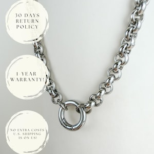 Puede incluir: Un collar de cadena de metal plateado con eslabones gruesos y redondeados entrelazados y un cierre de resorte circular. El collar se muestra con tres superposiciones de texto circulares que dicen 30 DAYS RETURN POLICY, 1-YEAR WARRANTY y NO EXTRA COSTS U.S. SHIPPING IS ON US.