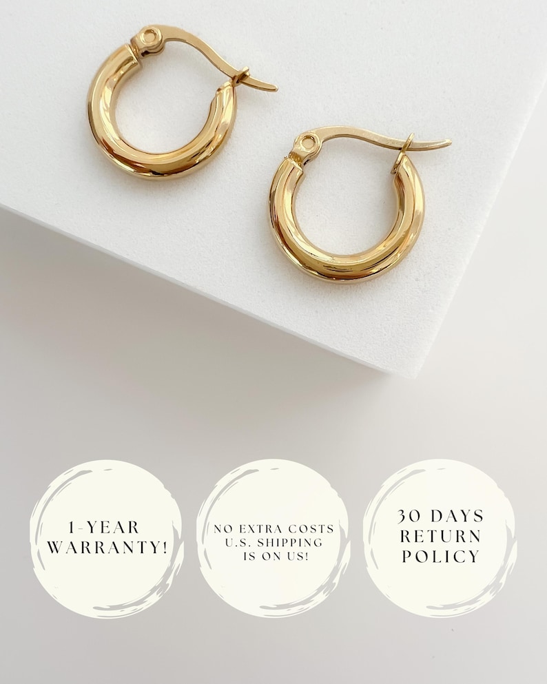 May include: A pair of gold-colored hoop earrings. The earrings have a classic, rounded design and a polished finish. The image is set against a white background. The earrings are a timeless jewelry accessory.