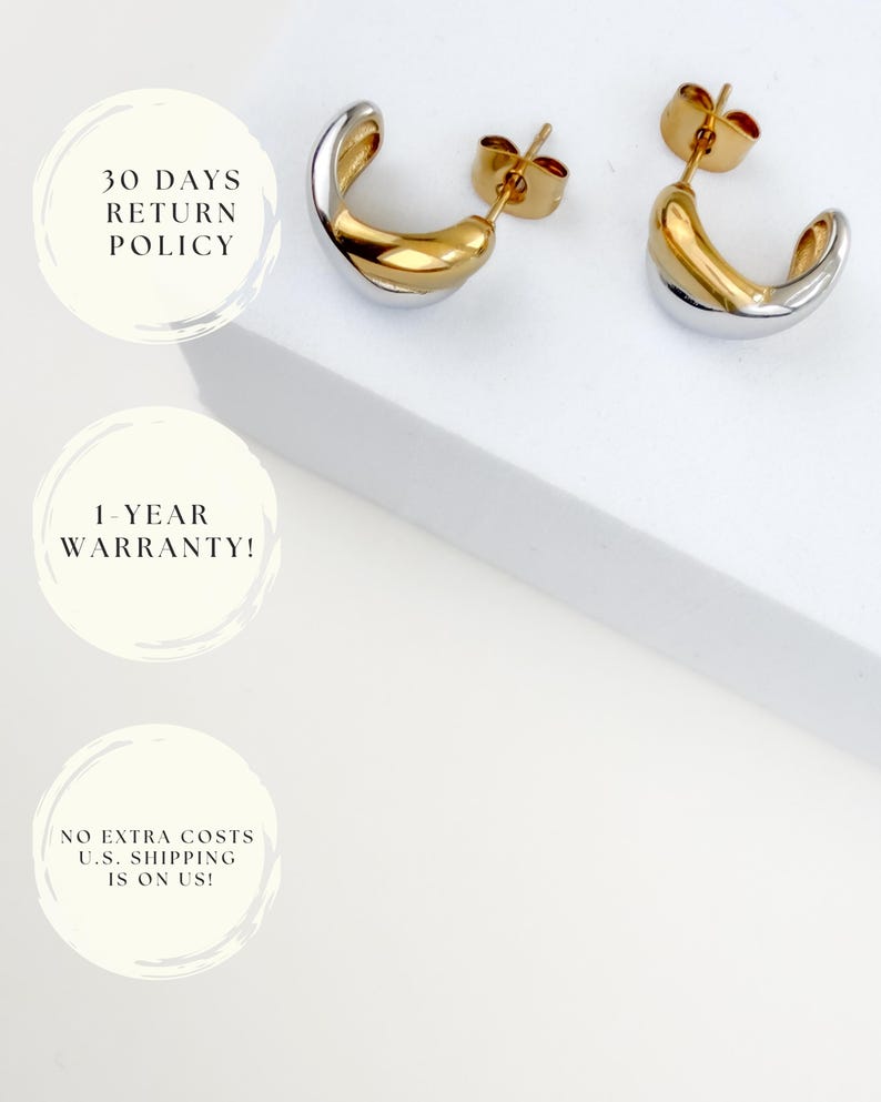 May include: A pair of two-tone gold and silver hoop earrings. The earrings have a curved design with a gold interior and a silver exterior. The earrings are displayed on a white surface.