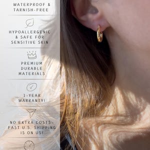 May include: A close-up of a gold hoop earring. The earring is worn on the ear of a person. Text on the left side of the image reads: WATERPROOF & TARNISH-FREE, HYPOALLERGENIC & SAFE FOR SENSITIVE SKIN, PREMIUM DURABLE MATERIALS, 1-YEAR WARRANTY!, and FAST PROCESSING 1-2 DAYS.