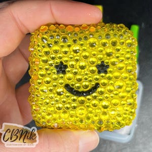 May include: A white ceramic mug with a black handle and the text "But first, coffee" in a black, handwritten-style font. The mug is on a white surface.