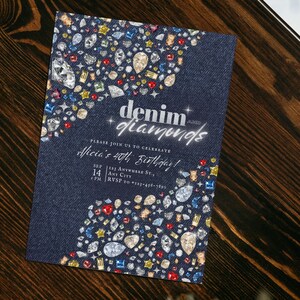 Può includere: Un invito blu denim con un design glitter argentato che dice "denim diamonds" e "Unisciti a noi per celebrare il 40° compleanno di Alicia!" L'invito è decorato con diamanti colorati.