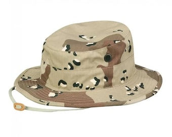 May include: A tan and brown camouflage boonie hat with a chin strap.