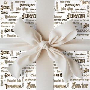 May include: A gift box wrapped in white paper with a large ivory bow. The paper is printed with religious words in gold and black, including "Jesus," "Jehovah," and "Savior." The bow is tied in a classic style, adding a touch of elegance.