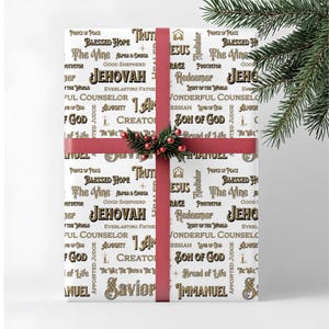 May include: White gift wrap with religious text in black and gold, including "Jehovah" and "Jesus". A red ribbon and a sprig of berries and greenery adorn the wrapped gift, perfect for a Christmas or religious occasion.