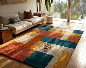 Alfombra de lana tejida a mano, moderna, con bloques de colores geométricos, en verde azulado, naranja y mostaza.