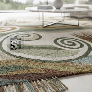 Puede incluir: Primer plano de una alfombra con un dise&ntilde;o en espiral en tonos verdes, marrones y crema. La alfombra tiene un borde con flecos y el texto "SAJDA HOME" es visible. La alfombra est&aacute; sobre un suelo de madera clara.