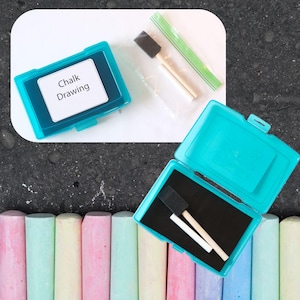 May include: A set of colorful chalk sticks in a blue plastic container with a sponge and two wooden sticks. The container has a label that says "Chalk Drawing".