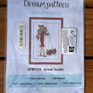 May include: Cross stitch pattern for a woman walking two Scottish terriers. The pattern is called "Great Scotts" and is available in three sizes: 18 count, 14 count, and 11 count. The pattern is made with cotton thread.