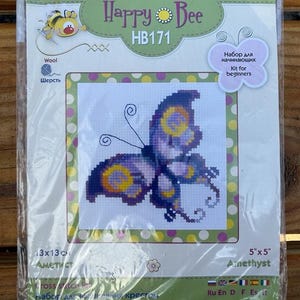 May include: A cross stitch kit featuring a purple butterfly with yellow accents. The kit is titled "Happy Bee" and includes the text "HB171" and "Ainethyst".