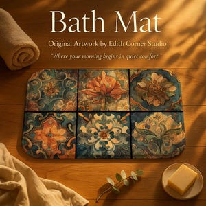 Op de afbeelding: Een rechthoekige badmat met een bloemen tegelontwerp in tinten blauw, oranje en crème. De mat heeft de tekst "Bath Mat" en "Original Artwork by Edith Corner Studio". De quote "Where your morning begins in quiet comfort" is ook zichtbaar.