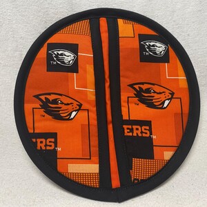 May include: Orange and black pot holder with a beaver logo and the word "ERS" printed on it.
