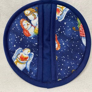 Puede incluir: Manopla azul con una escena de invierno con muñecos de nieve y copos de nieve. La manopla está hecha de tela y tiene un lazo para colgar.