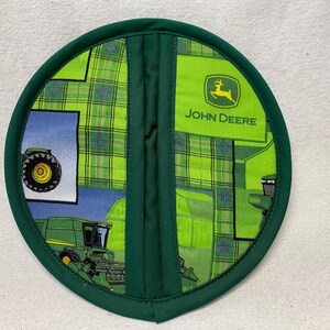 May include: Green and yellow round pot holder with a John Deere logo and a tractor design.