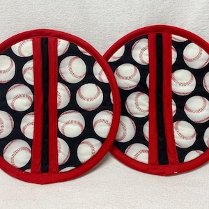 May include: Two red and black pot holders with a baseball pattern. The pot holders have a black stripe down the center.