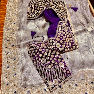 May include: A luxurious ensemble featuring a silver-gray fabric with intricate patterns and gold embellishments. Two ornate, velvet blouses in deep purple and black are adorned with gold sequins and embroidery. A traditional, elegant design.