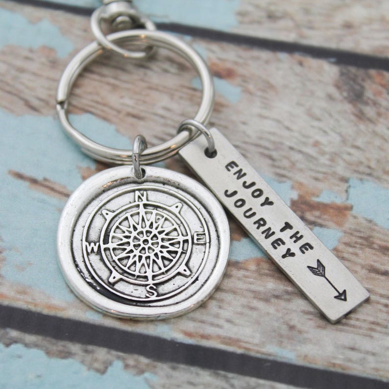 May include: Silver compass keychain with a silver tag that reads "Enjoy the Journey".