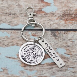 May include: Silver compass keychain with a silver tag that reads "Enjoy the Journey".