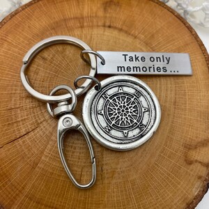 May include: Silver keychain with a compass charm and a tag that reads "Take only memories..."