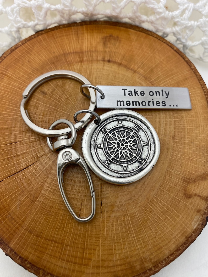 May include: Silver keychain with a compass charm and a tag that reads "Take only memories..."