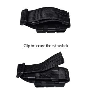 May include: Two black elastic straps with plastic clips, designed to secure extra slack. The text "Clip to secure the extra slack" is displayed below the straps. The straps are shown in two different configurations.