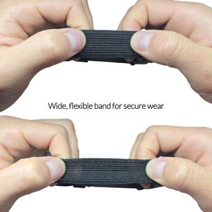 May include: Close-up of a wide, black, flexible band being stretched between two hands. The band has a textured surface. Text on the image reads: "Wide, flexible band for secure wear."