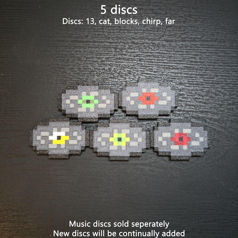 May include: Five pixelated music discs with gray circular bodies and distinct colored centers in green, red, yellow, lime, and dark red. Text reads: 5 discs, Discs: 13, cat, blocks, chirp, far, Music discs sold separately, New discs will be continually added.