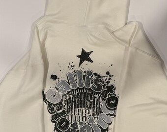 May include: White hoodie with a black star on the hood and a black and white graphic on the back that says "Callisto Clothing" with a star and splattered paint.