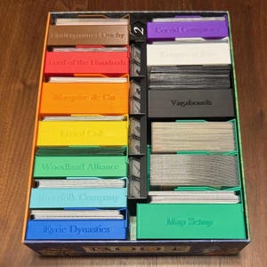 Organizador completo Root para todas las expansiones, incluyendo espacio para cartas con fundas y piezas protegidas con monedas o plástico. Juego de mesa Root.