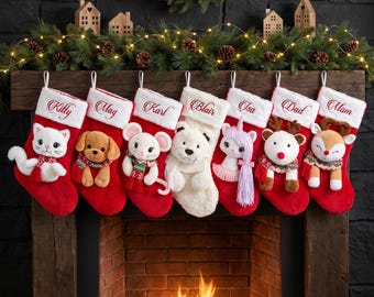 Op de afbeelding: Zeven kerstsokken hangen op een rij, elk met een pluche dier en een witte boord geborduurd met de namen: Kitty, Mag, Karl, Blair, Isa, Dad en Mom. De sokken zijn rood, behalve één witte sok.