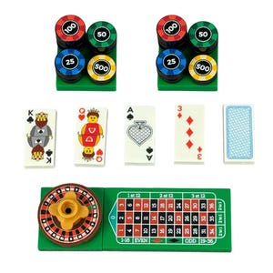May include: A collection of casino-themed game pieces, including stacks of poker chips in red, green, blue, and yellow, playing cards, and a roulette wheel with a green betting layout. The chips are labeled with values.