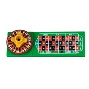 Op de afbeelding: Een miniatuur casinoroulettespel met een groene vilt lay-out en een draaiend wiel. Het wiel is bruin en geel, en de lay-out bevat nummers, inzetgebieden en de tekst "1st 12", "2nd 12", "3rd 12", "EVEN" en "ODD".