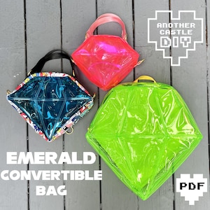 Könnte beinhalten: Drei durchsichtige, diamantförmige Plastiktüten mit unterschiedlichfarbigen Innenräumen. Die Taschen sind alle geschlossen und haben einen Griff. Die Taschen befinden sich auf einer grauen Holzoberfläche. Der Text "EMERALD CONVERTIBLE BAG" befindet sich unten im Bild. Der Text "ANOTHER CASTLE DIY" befindet sich oben im Bild. Der Text "PDF" befindet sich unten rechts im Bild.